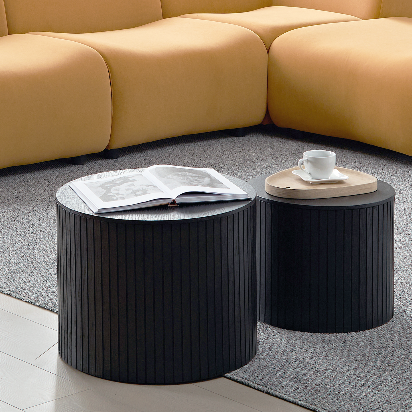 Black fluted drum coffee table with an open book perfect for modern living spaces