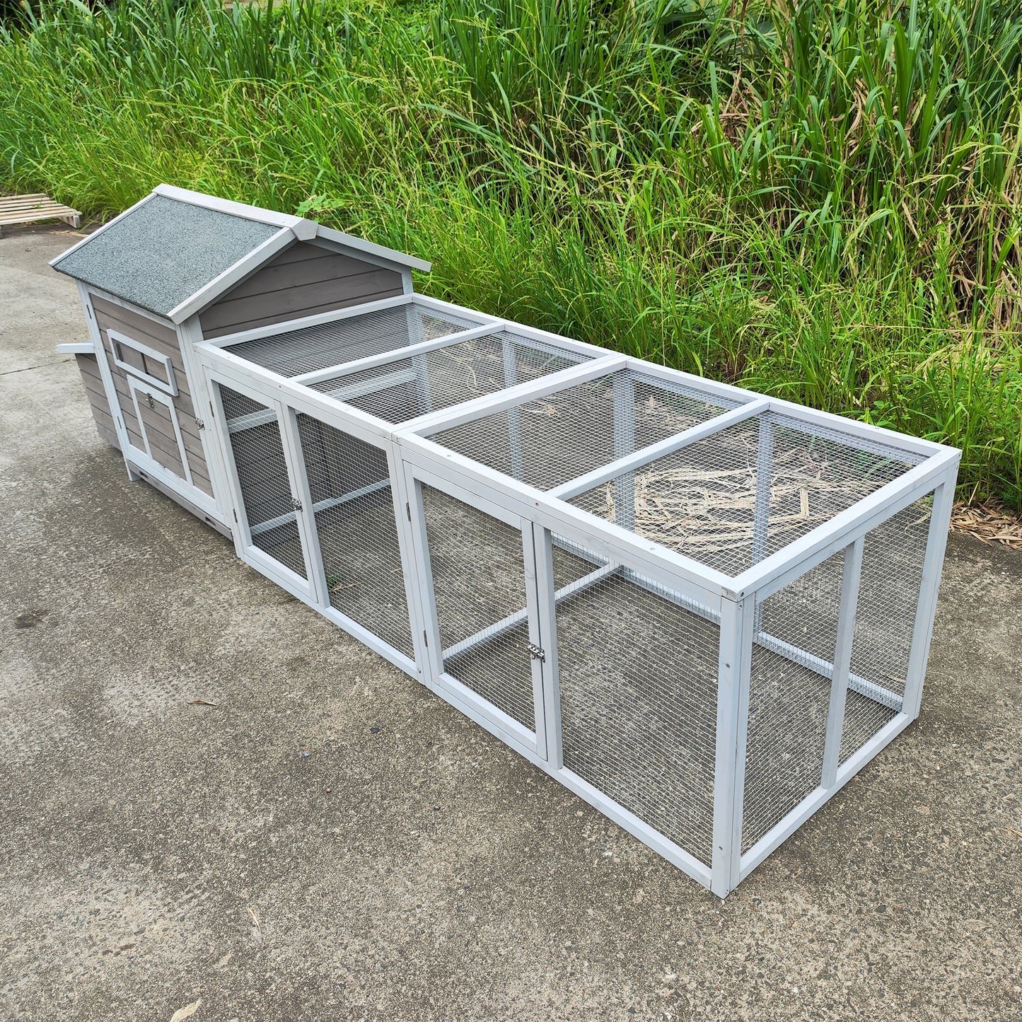 Long grey wooden chicken coop with twotiered run and metal mesh fencing
