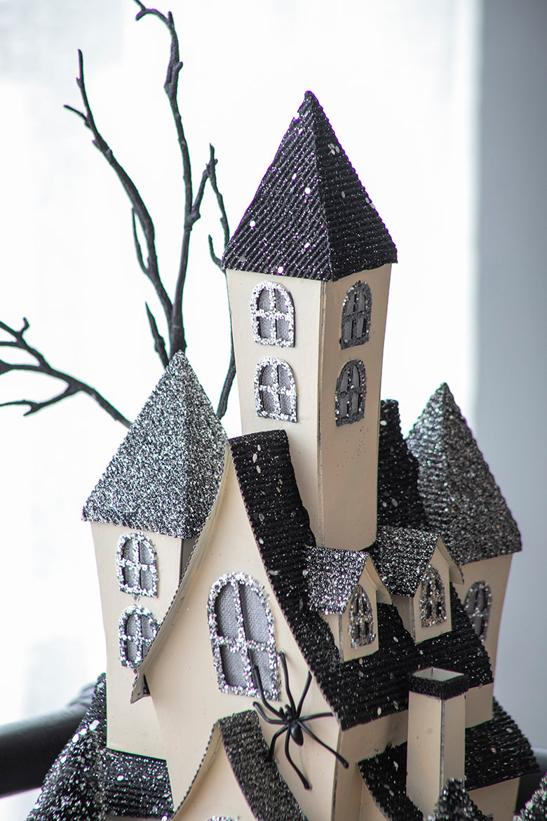 Glittering haunted house decoration with spooky black spider and bare branches