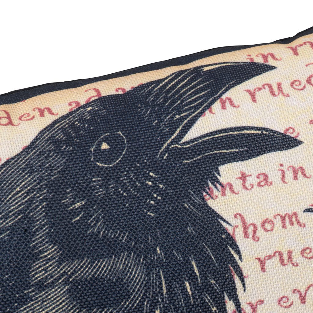 Closeup of a vintage raven print on a black and cream fabric throw pillow