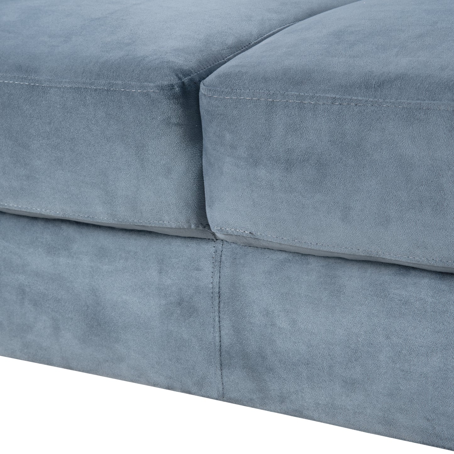 Closeup of a blue velvet sofa cushion showing textured fabric and stitching