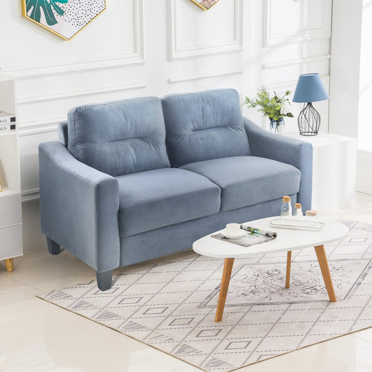 Plush blue velvet loveseat with tufted cushions perfect for a cozy living room