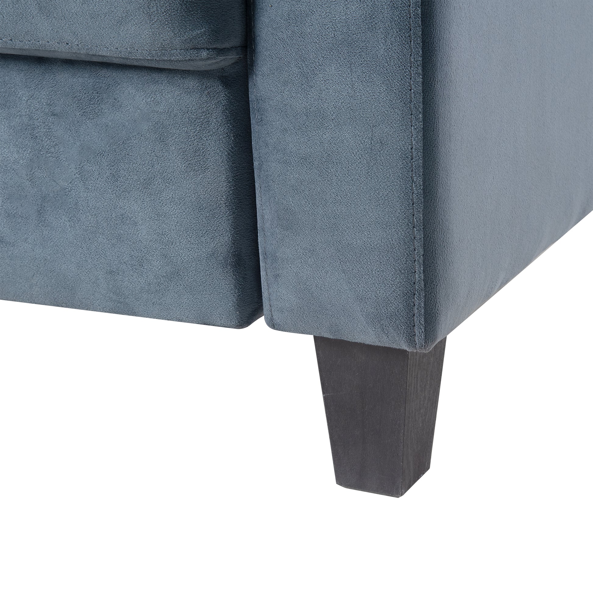 Closeup of a dark blue velvet armchair leg with wooden base