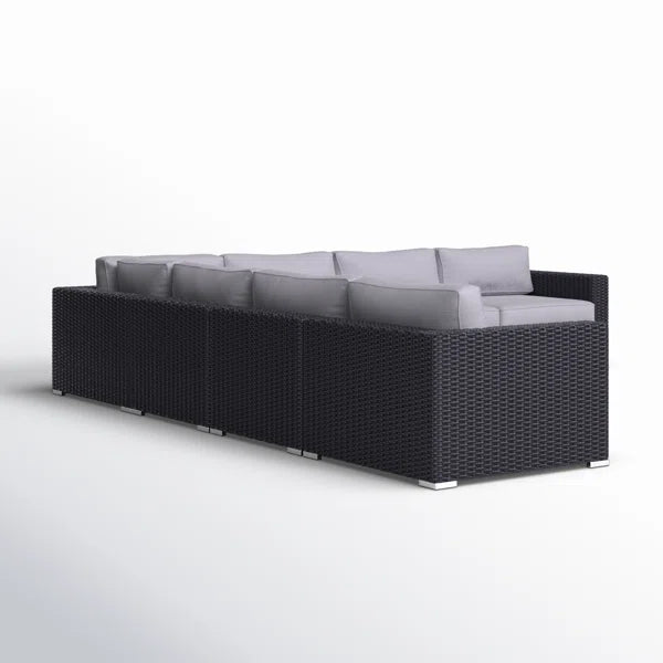 Black wicker sectional sofa with light grey cushions for outdoor seating