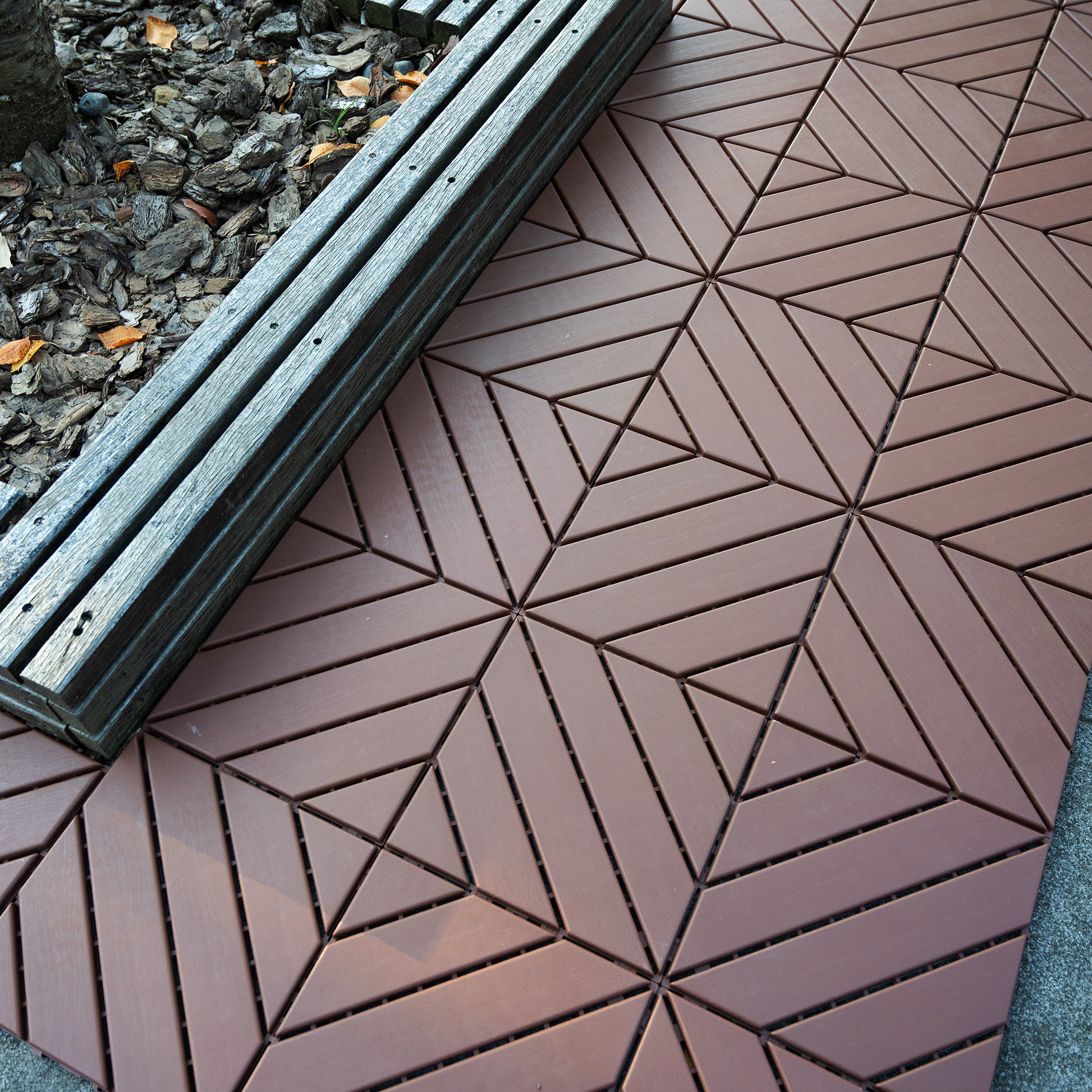 Brown interlocking deck tiles with a geometric pattern suitable for patios