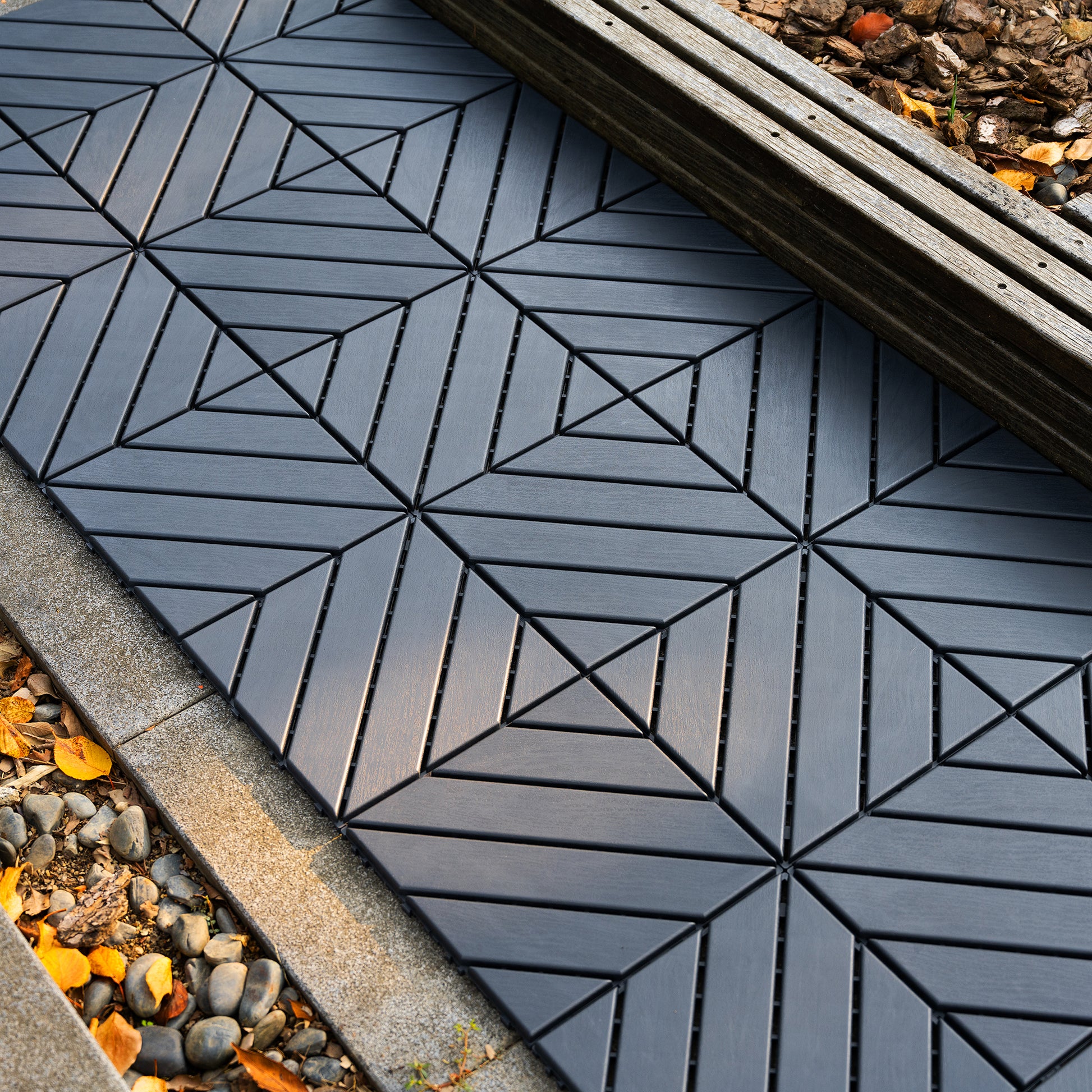 Dark grey interlocking deck tiles with a geometric pattern for outdoor patios