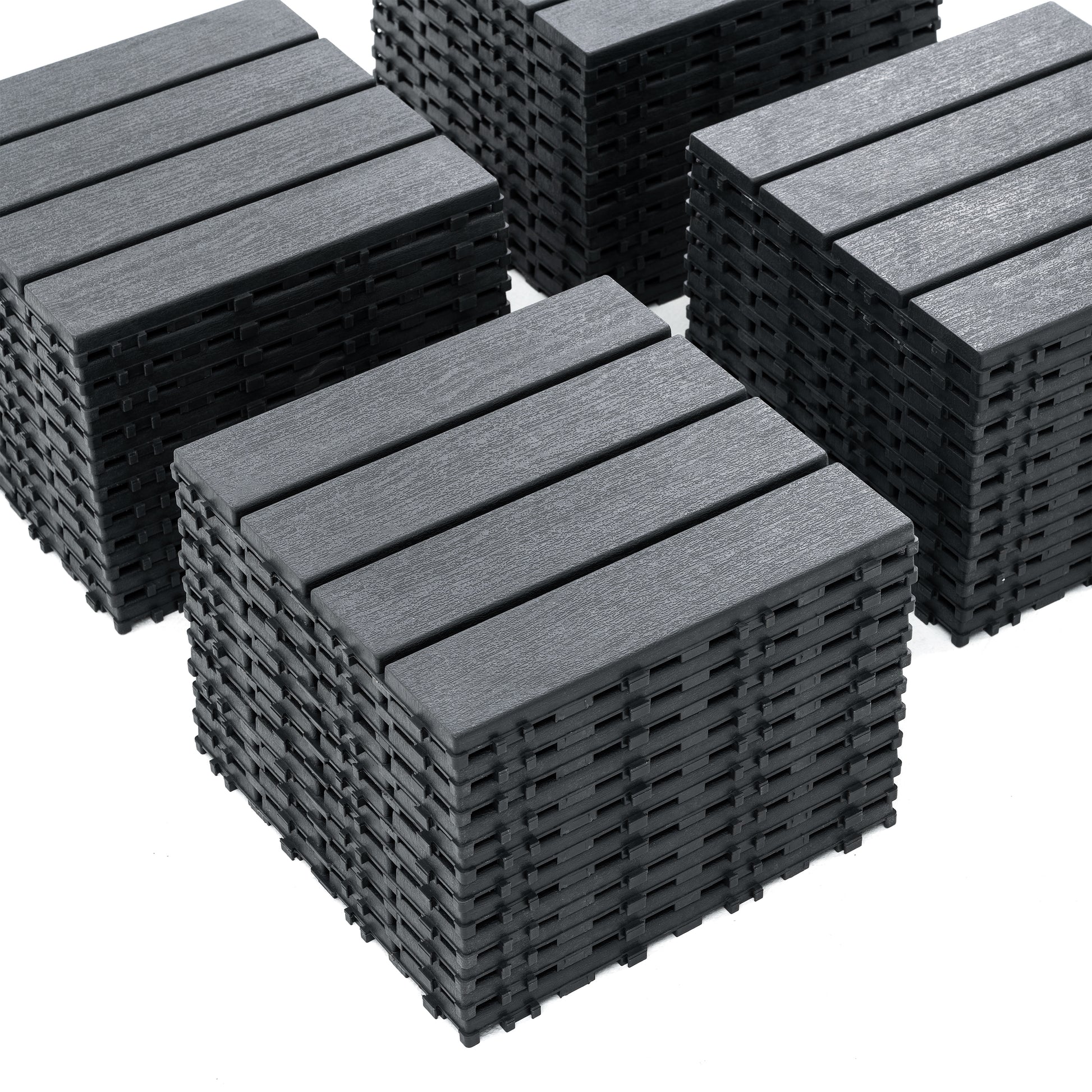 Four stacks of dark grey interlocking deck tiles with a wood grain texture