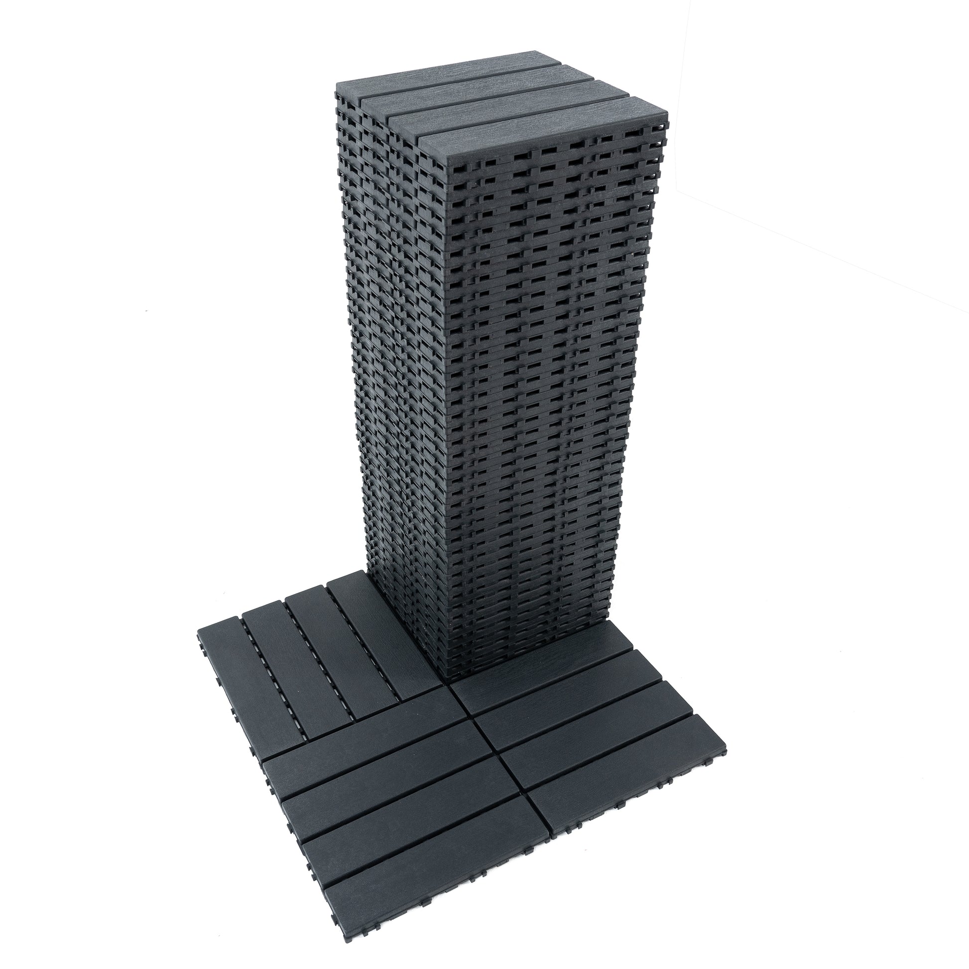 Stack of dark grey interlocking deck tiles showing their slatted surface and underside connectors
