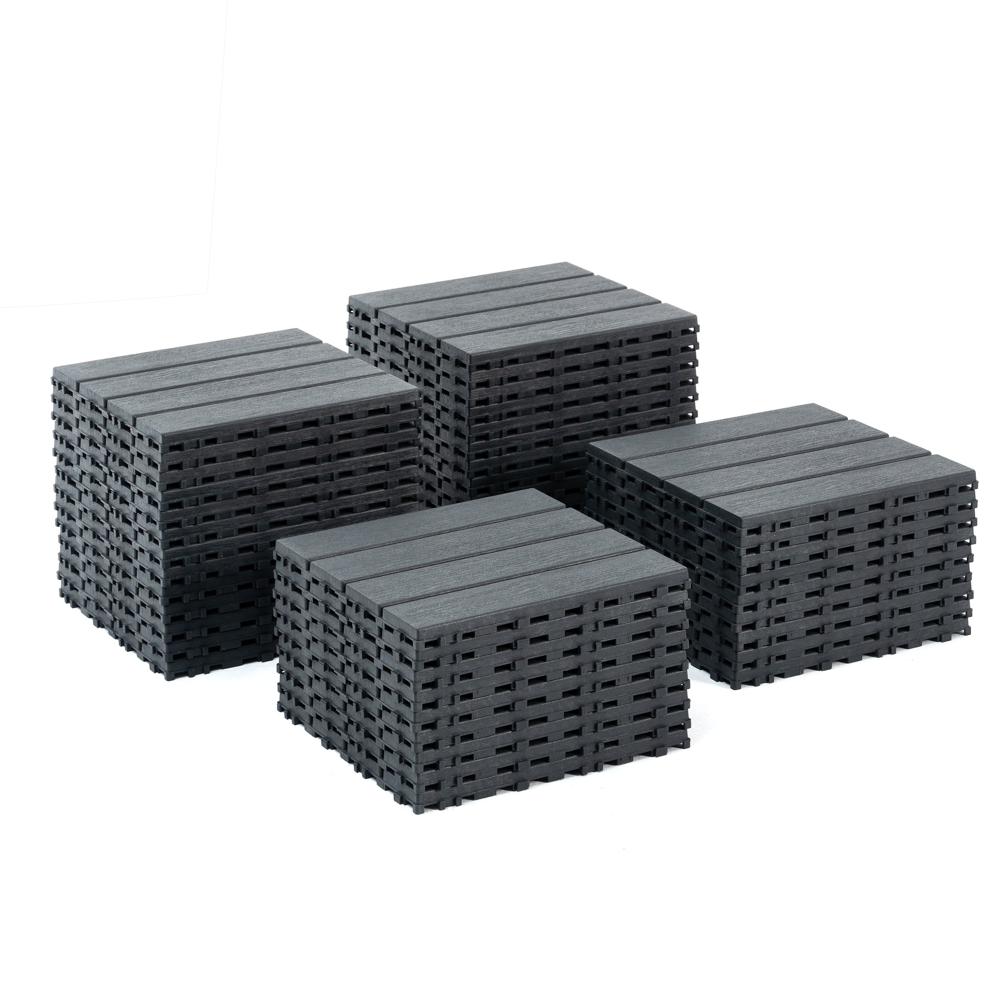 Dark grey composite decking tiles stacked in groups for outdoor patio use