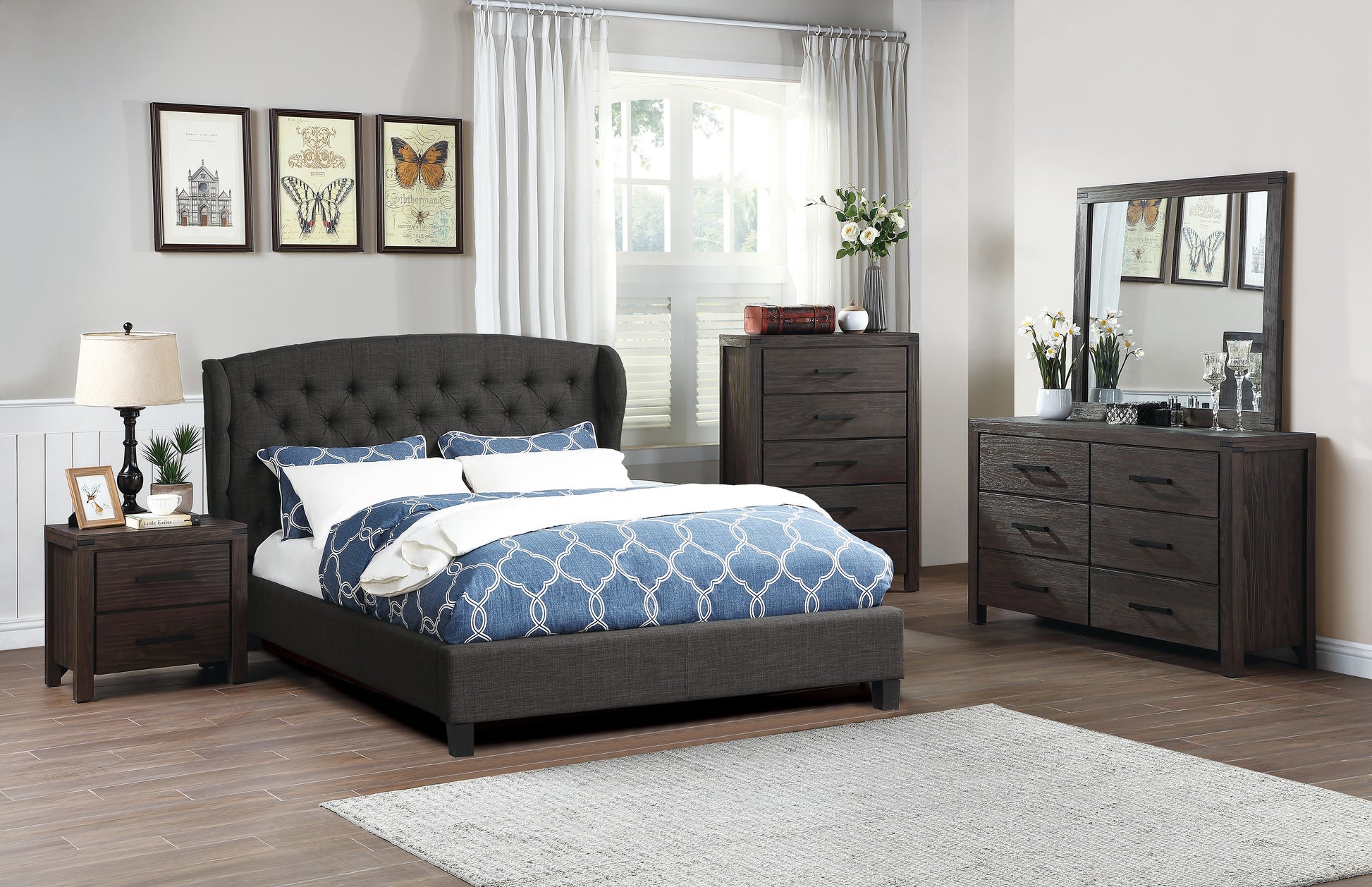 Dark grey upholstered bed with tufted headboard and blue patterned duvet