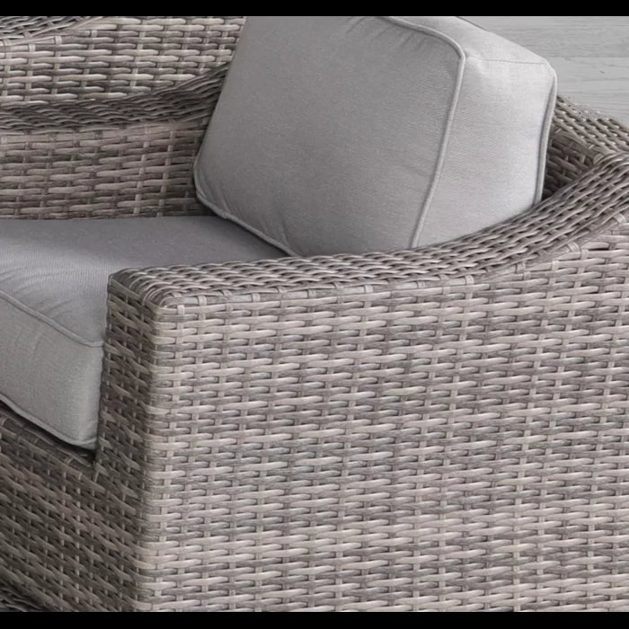 Close up of grey rattan armchair armrest with plush cushion