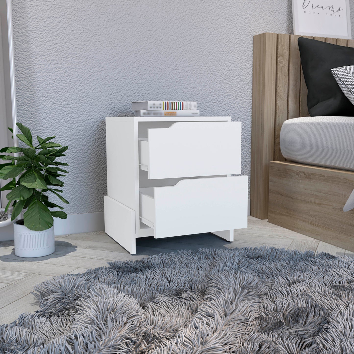 White twodrawer nightstand with modern cutout handles beside a bed