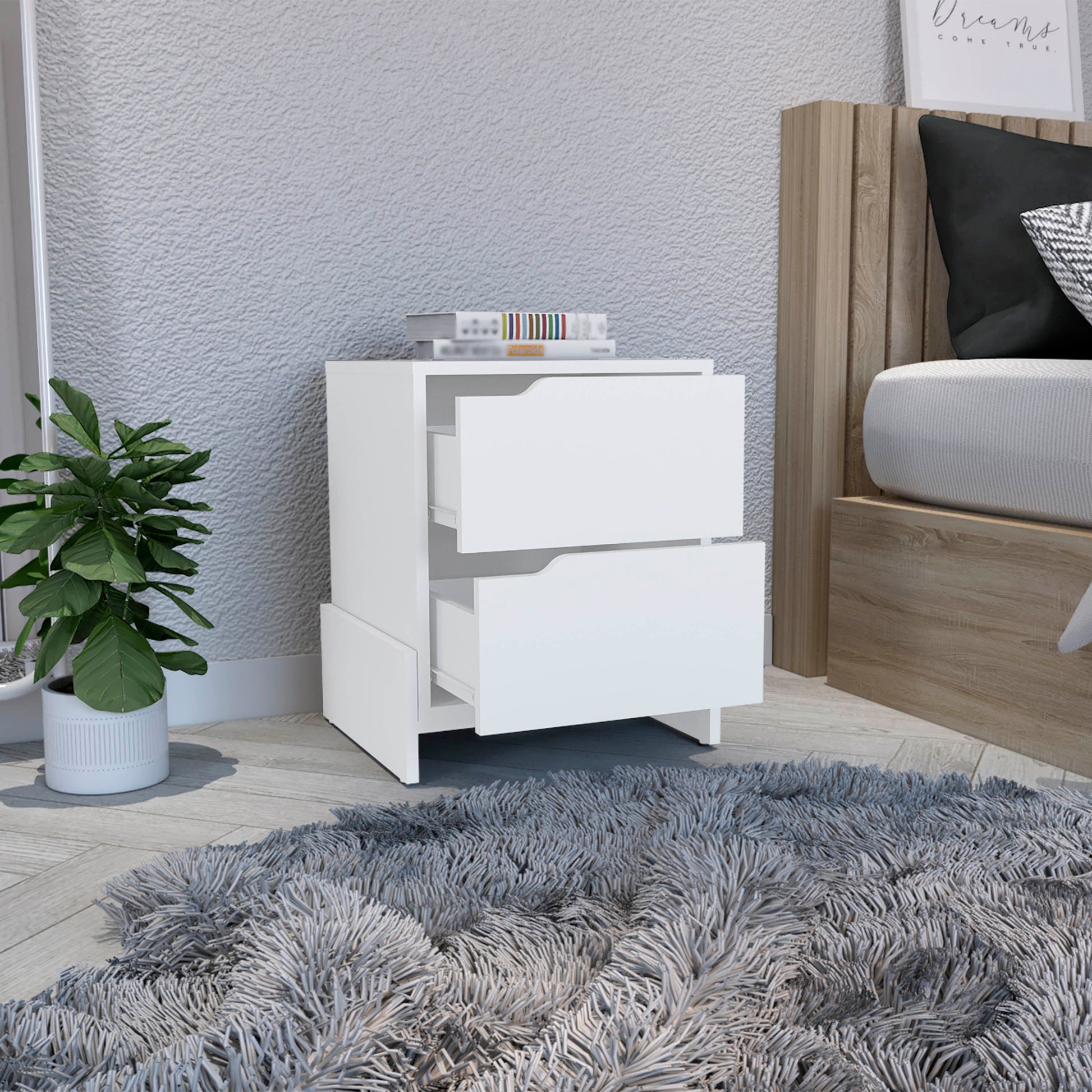 White twodrawer nightstand with modern cutout handles beside a bed