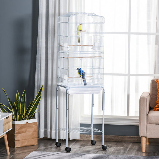 Tall white metal bird cage with yellow and blue birds perched inside