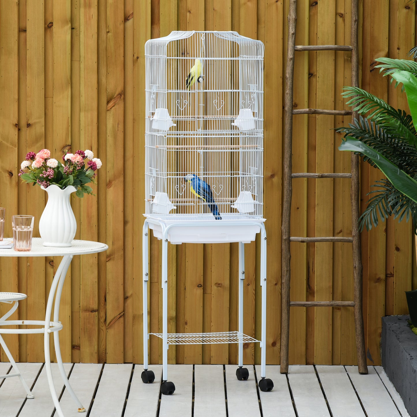 Tall white metal bird cage with two birds and wheeled stand