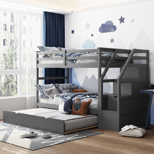 Gray wooden triple bunk bed with stairs and pullout trundle featuring navy bedding