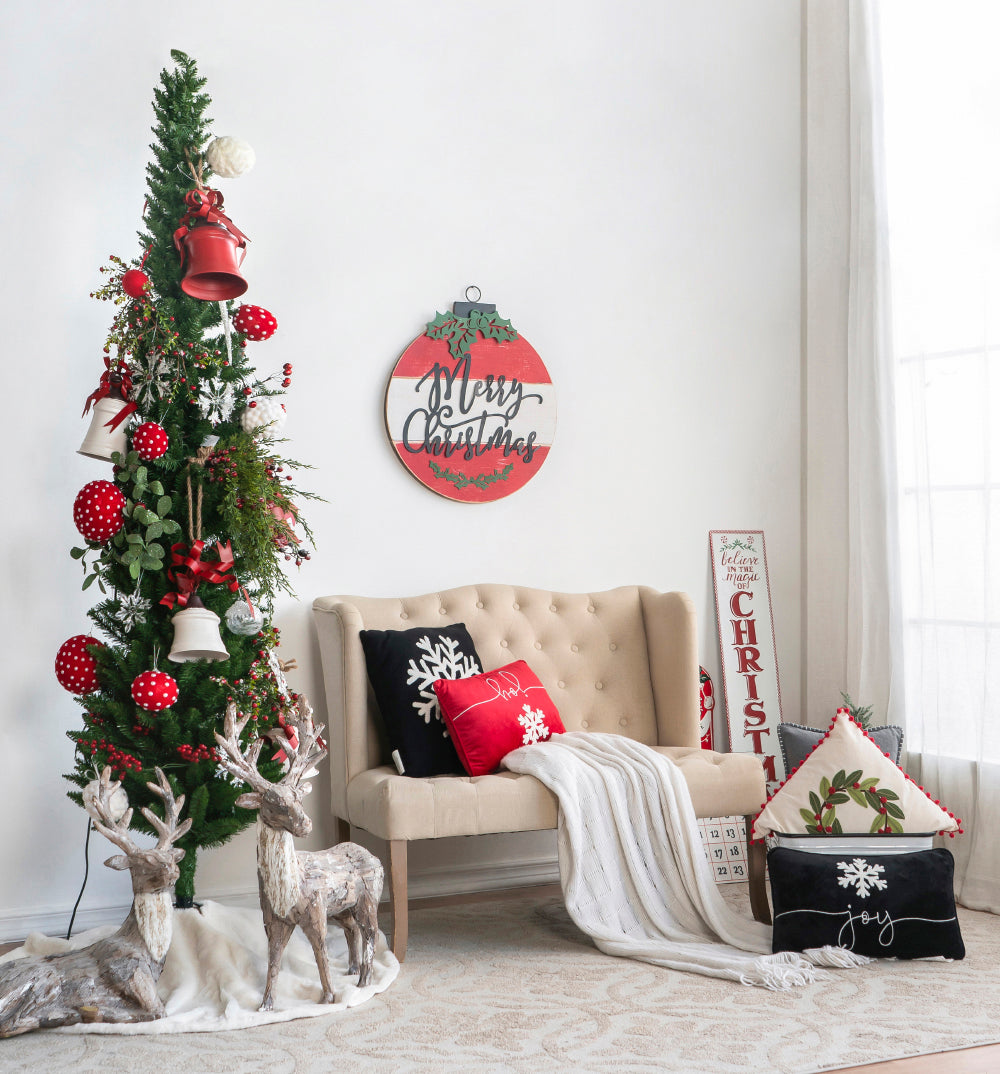 Tall slender artificial Christmas tree with red and white ornaments and bells