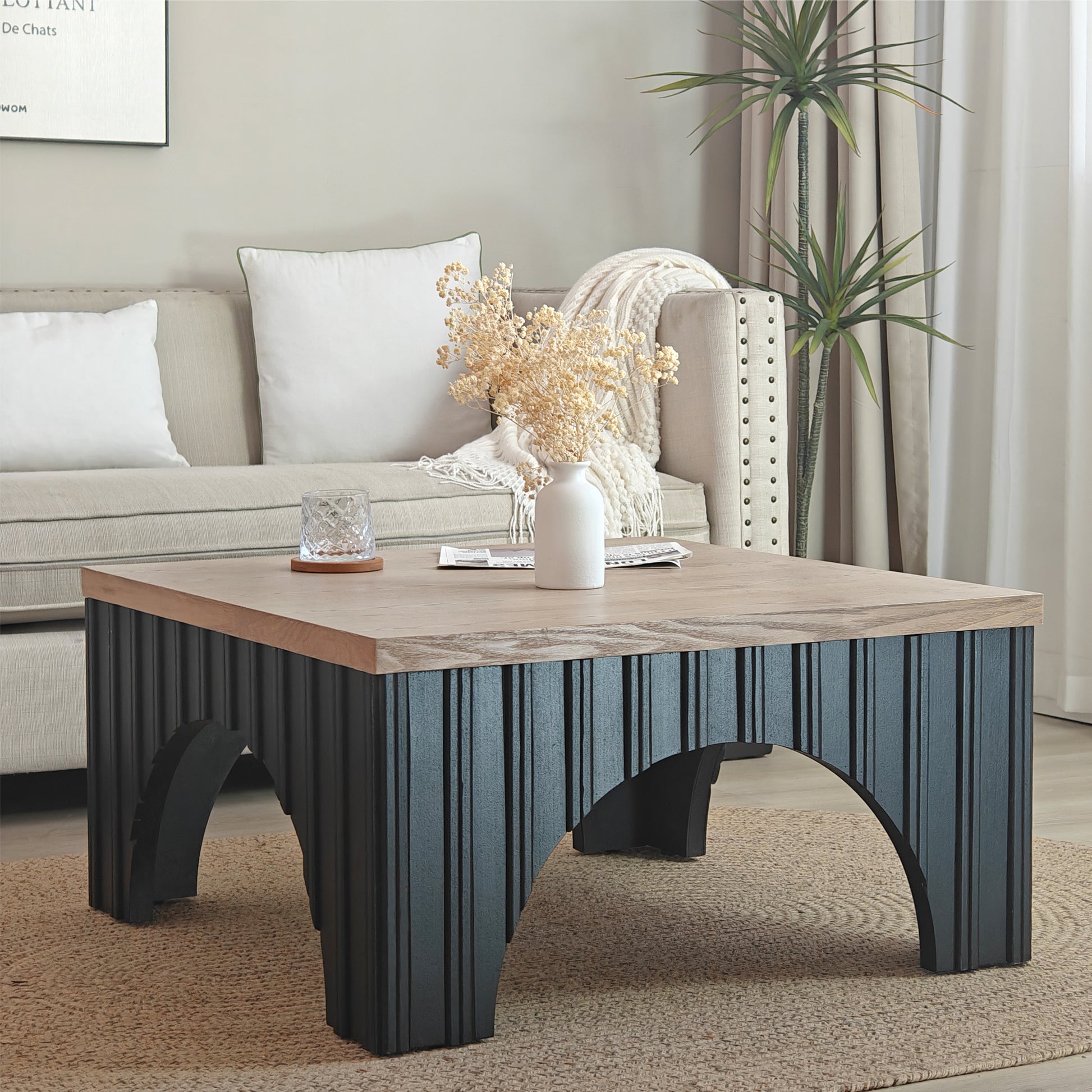 Modern square coffee table with light wood top and dark ribbed base