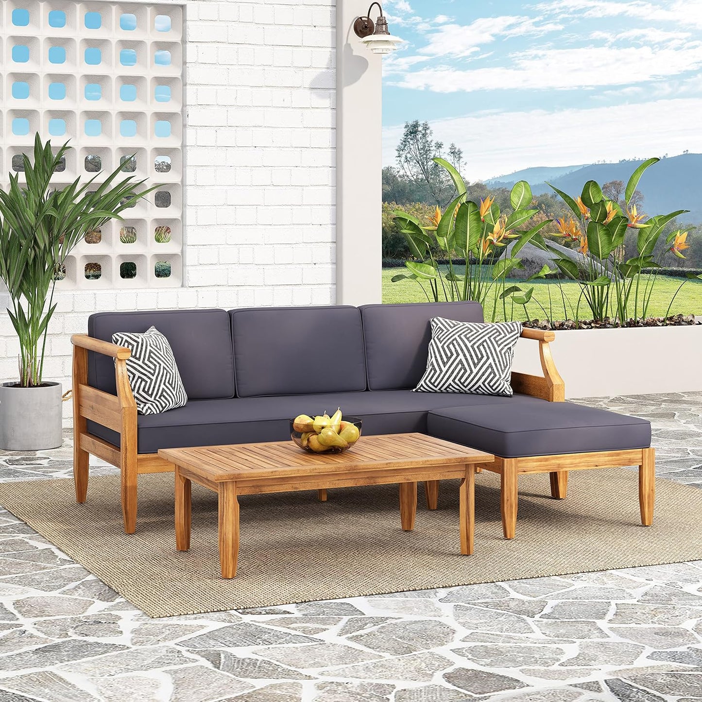 Teak wood sectional outdoor sofa with charcoal cushions and a modern coffee table