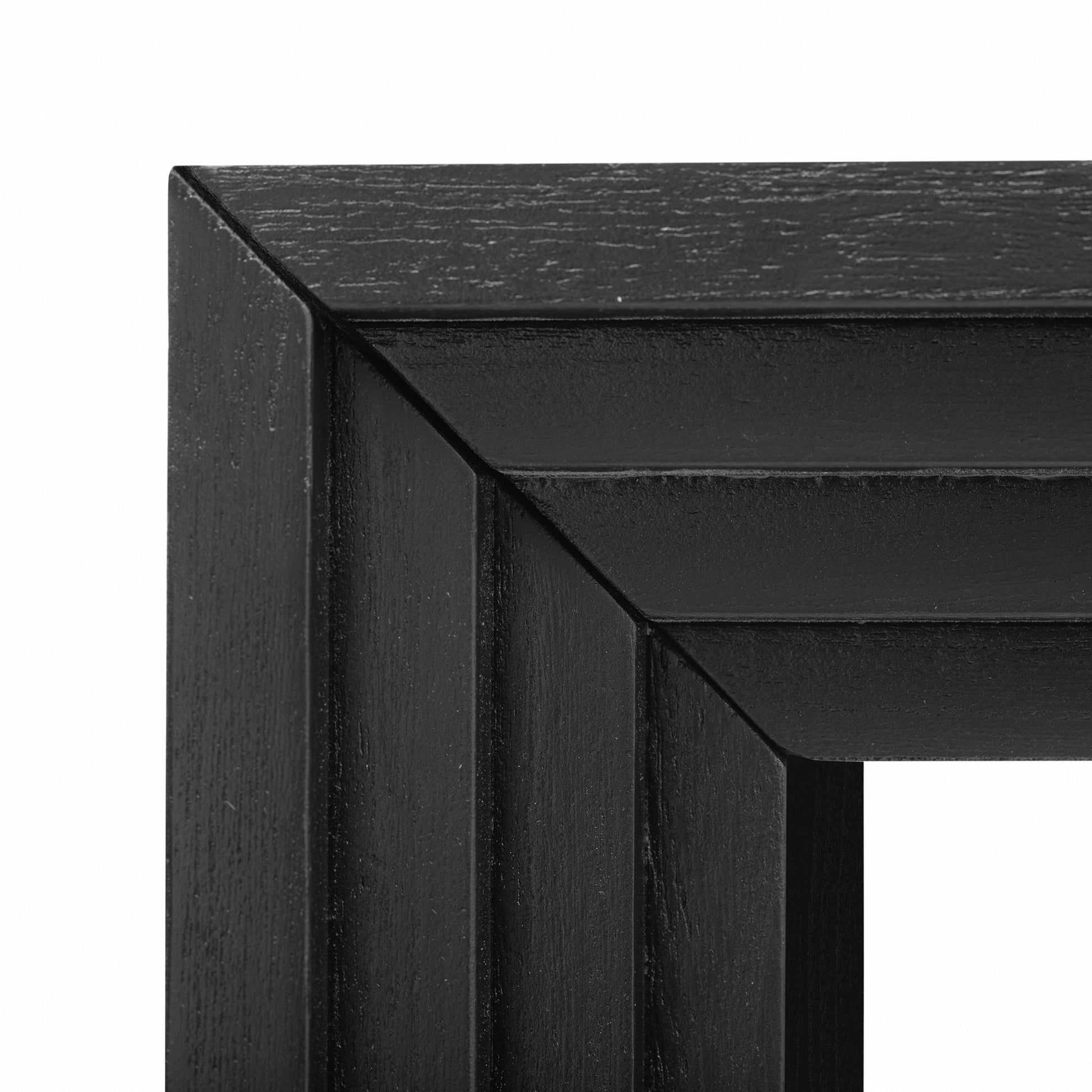 Closeup of a black wood picture frame corner with subtle textured grain detail