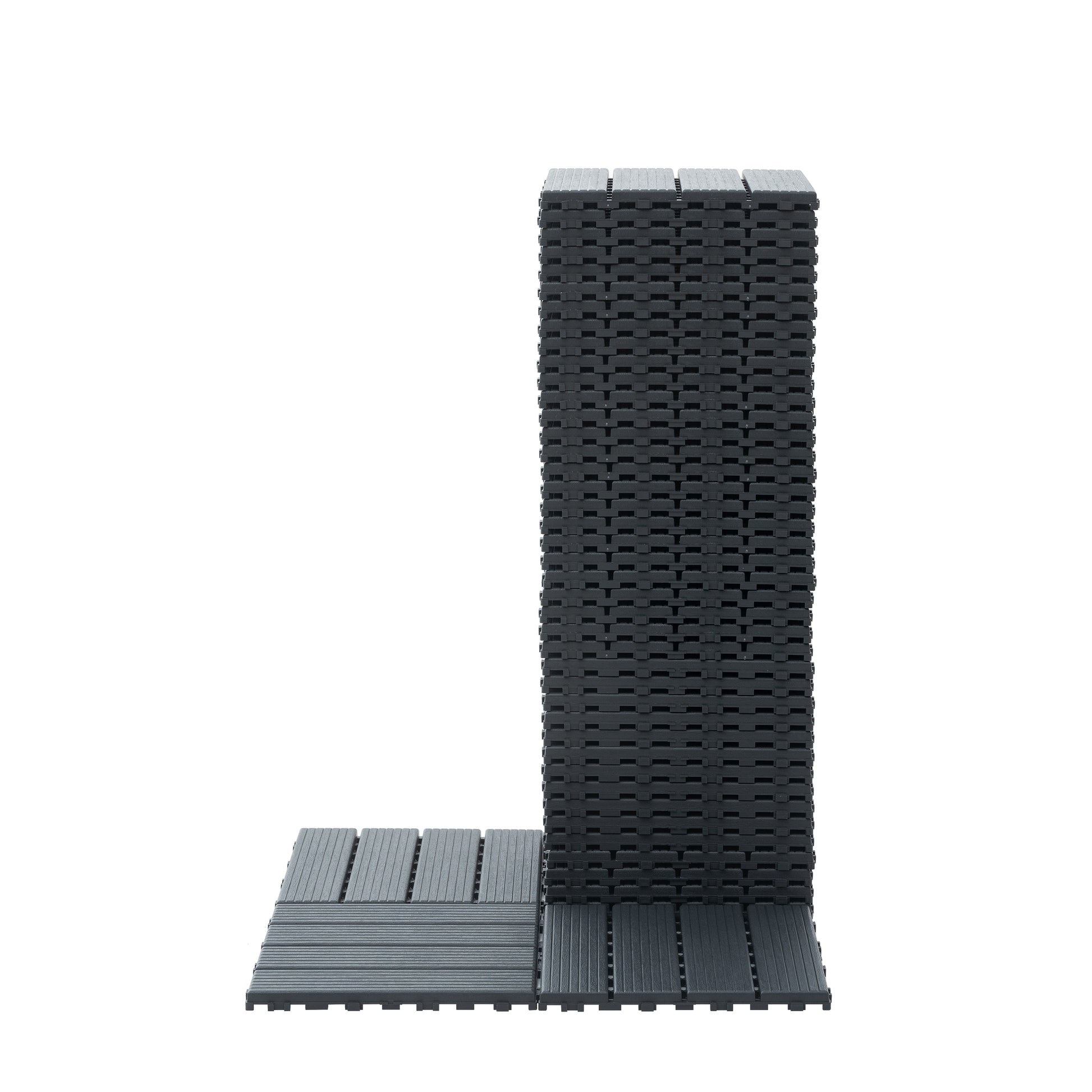 Stack of dark gray composite deck tiles with interlocking edges for easy installation