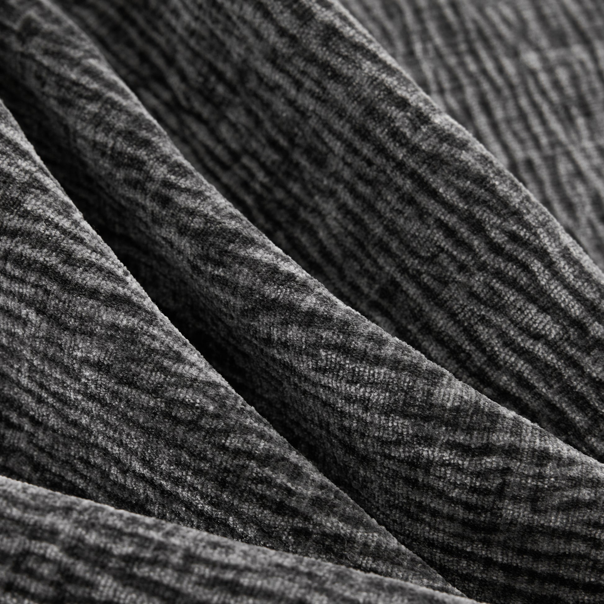 Closeup of charcoal grey textured velour fabric with subtle ribbed stripes