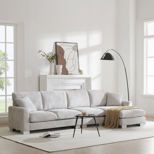 Light gray sectional sofa with chaise lounge and throw blanket perfect for living rooms