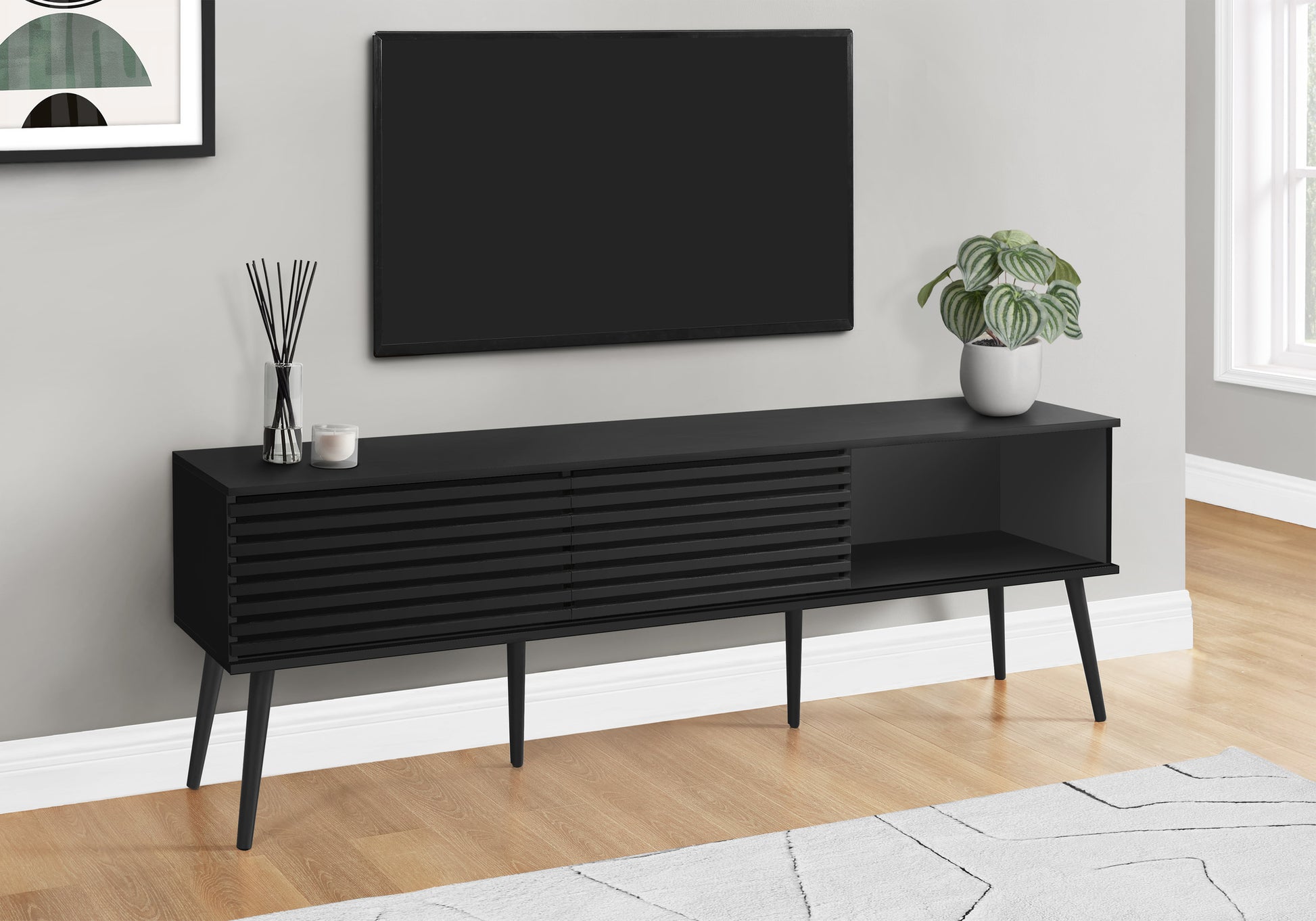 Modern black media console with ribbed drawer fronts and angled legs perfect for living rooms