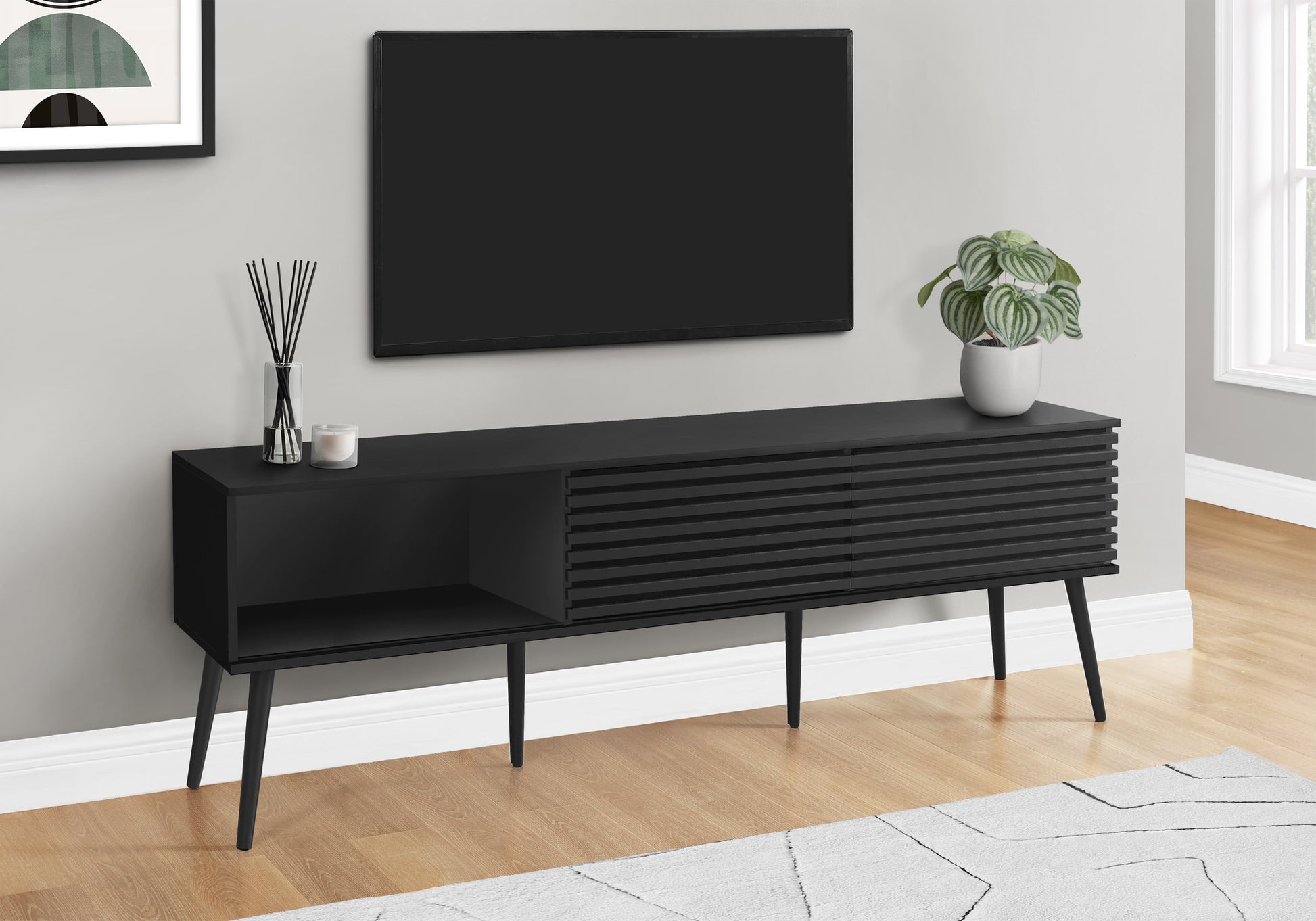 Sleek black media console with slatted door details and angled legs