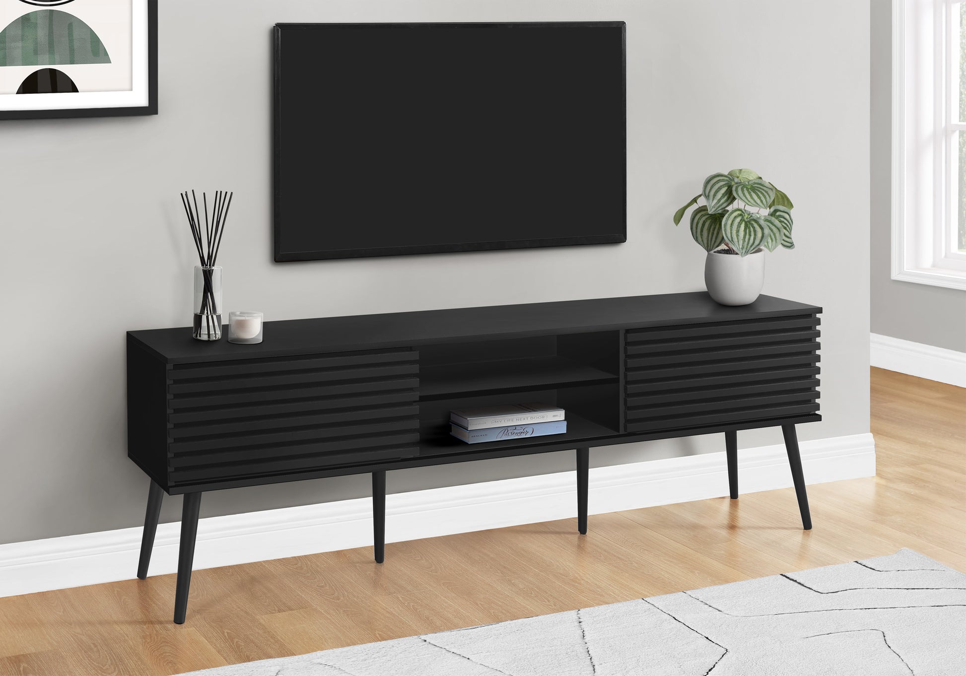 Sleek black media console with ribbed doors and tapered legs perfect for modern living rooms