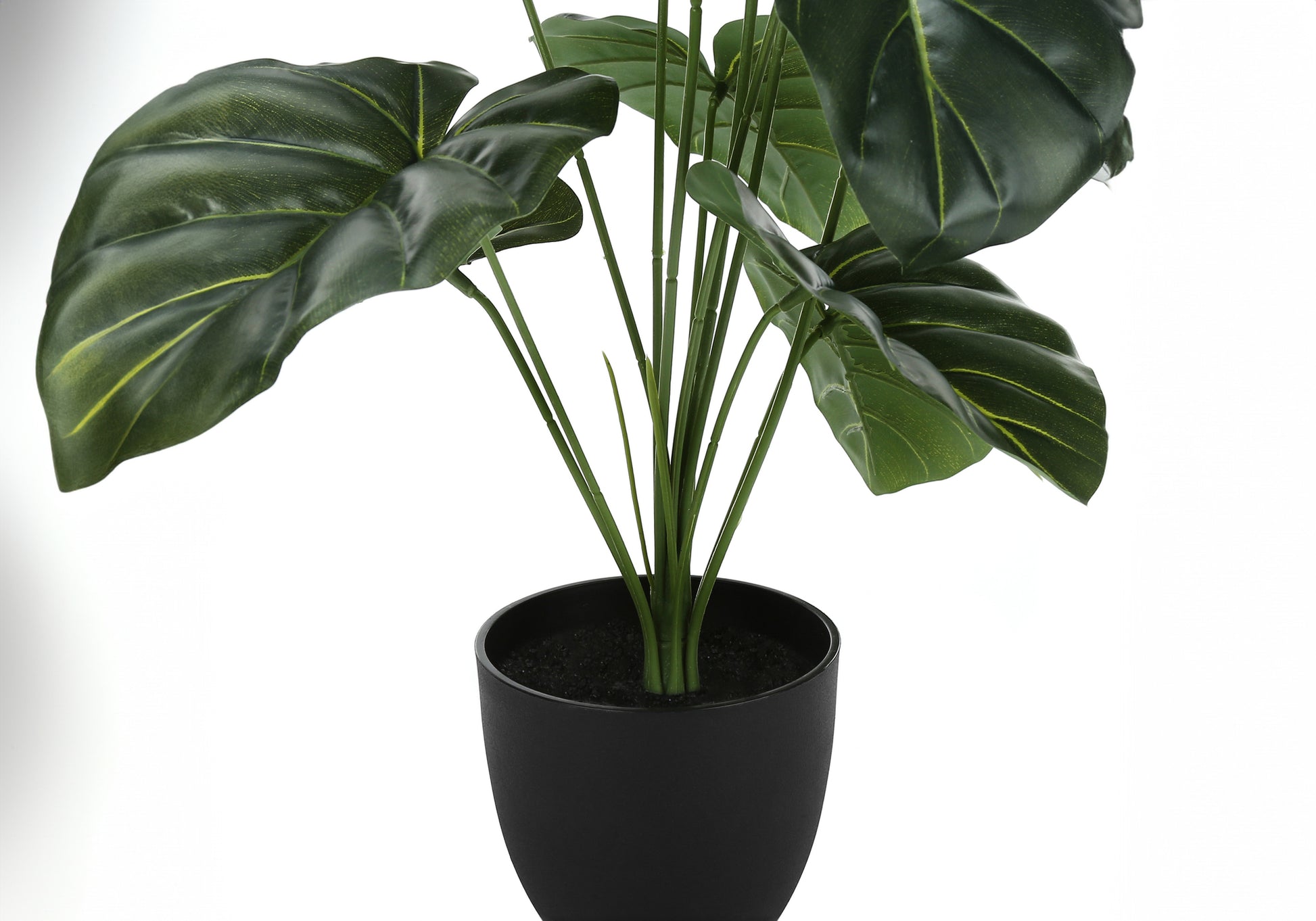 Realistic artificial elephant ear plant with large dark green leaves in a black pot