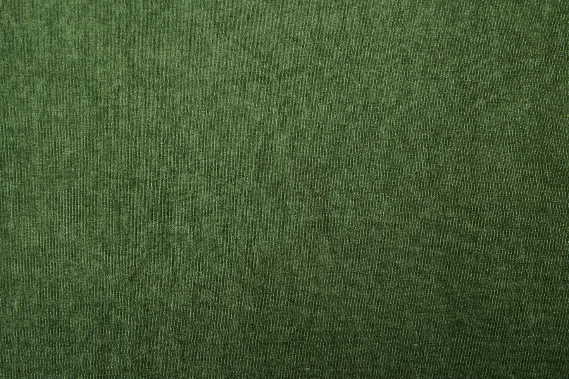Dark green velvet fabric texture closeup for upholstery