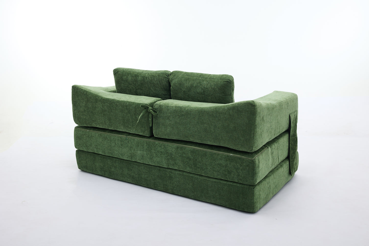 Modern green velvet sofa convertible into a bed with plush cushions and decorative ties