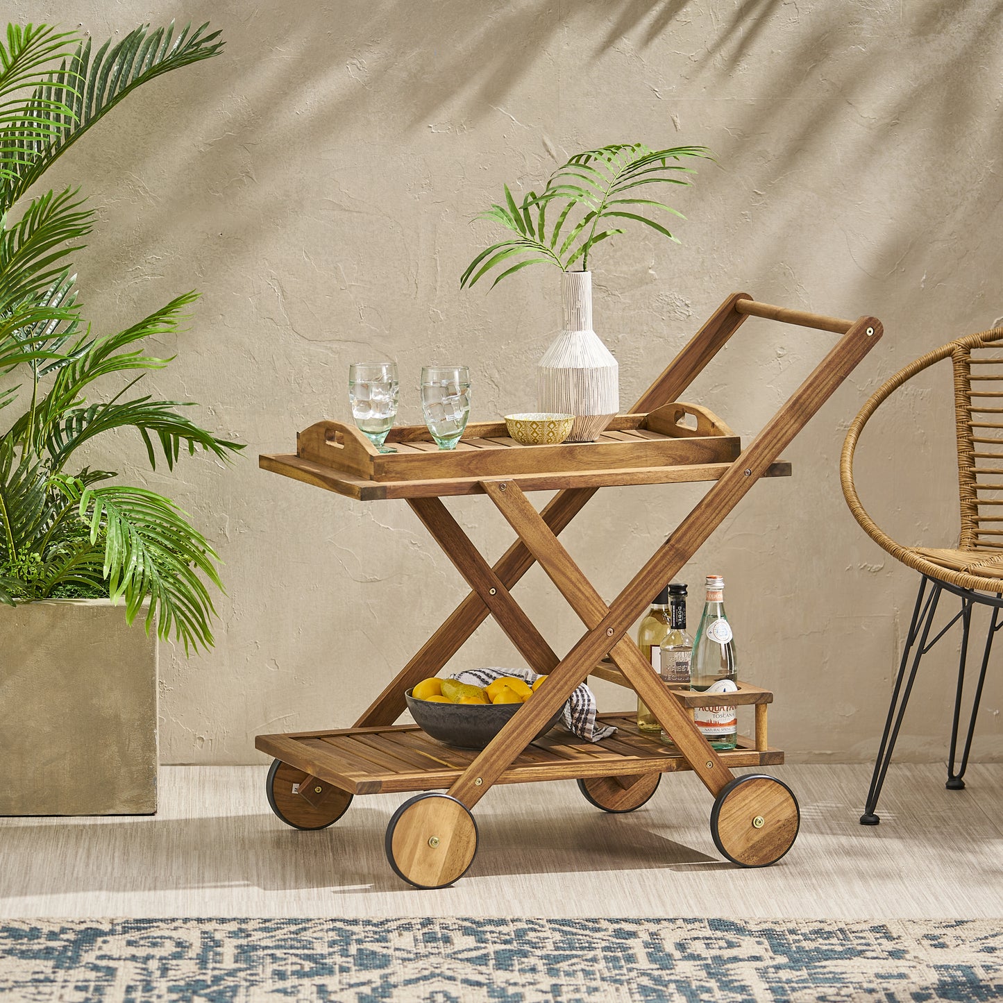 Wooden bar cart with two shelves holding drinks and snacks