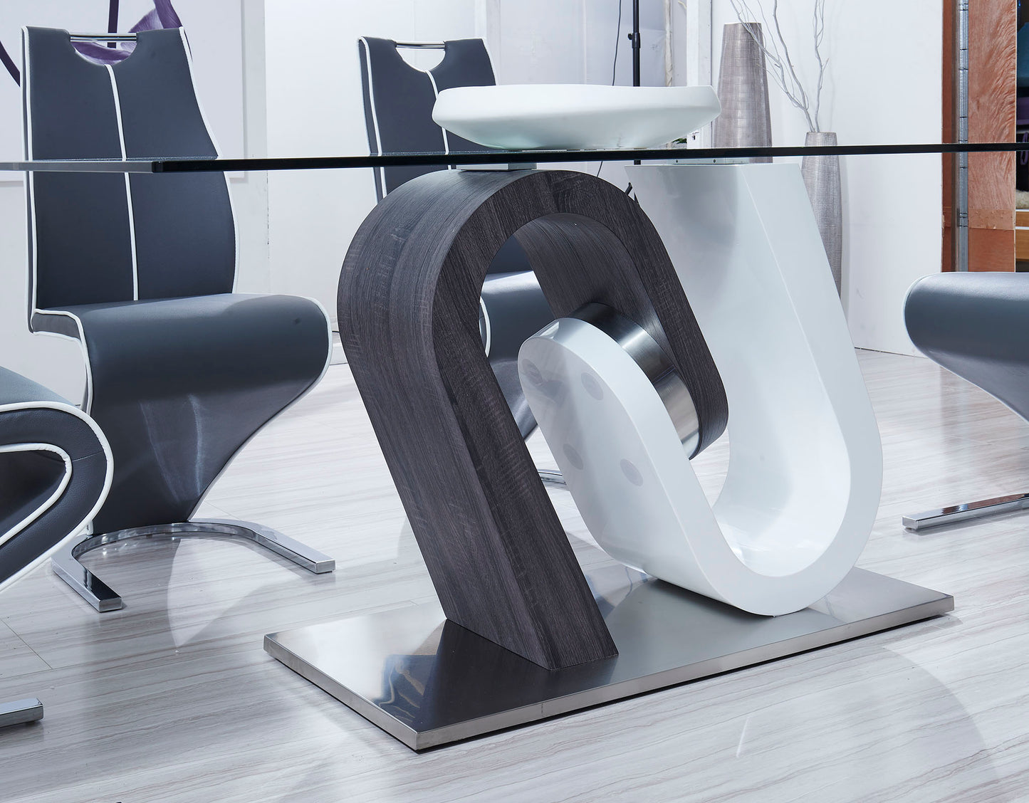 Modern glass dining table with a sculptural dark wood and white pedestal base