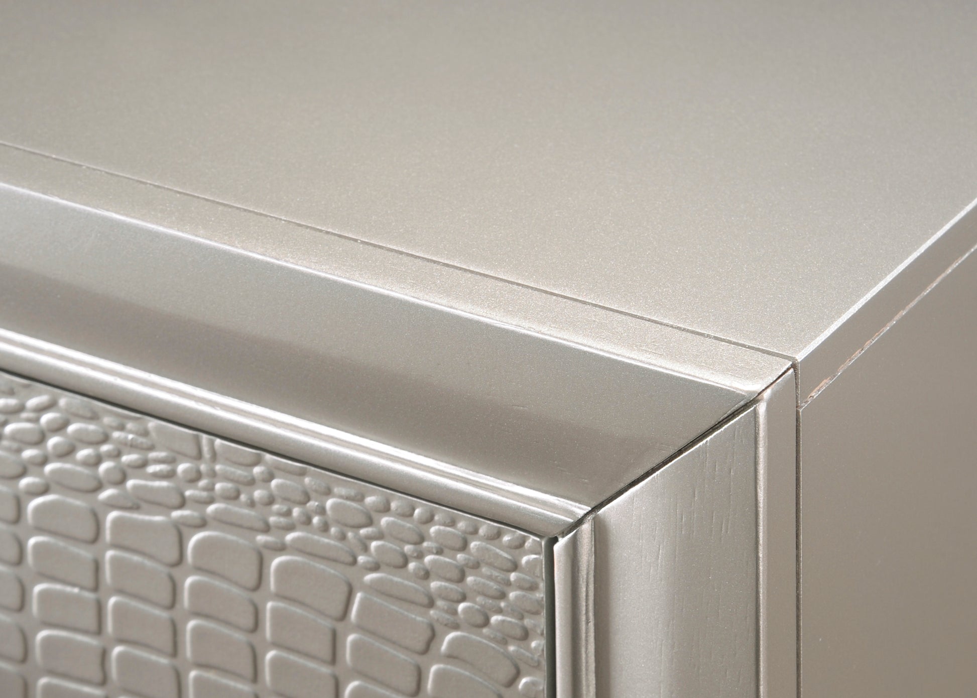 Closeup of champagne gold dresser drawer with embossed stone pattern texture