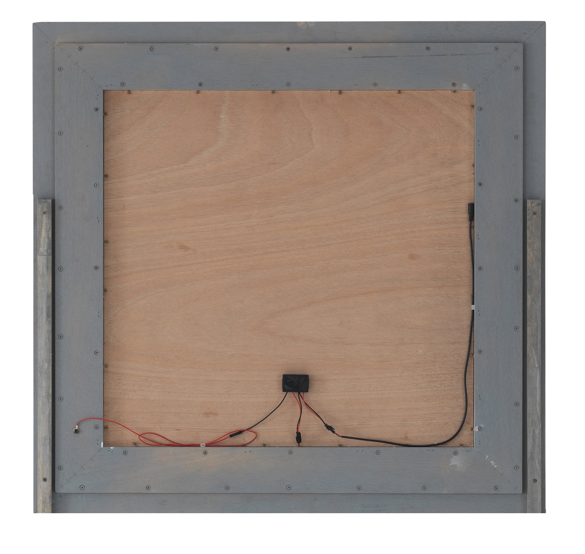 Back of grey framed lighted mirror with wood paneling and visible wiring