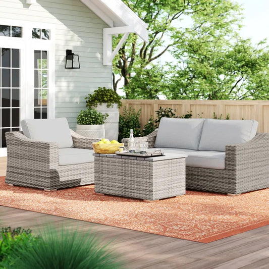 Gray wicker loveseat with light gray cushions on a patio perfect for outdoor seating