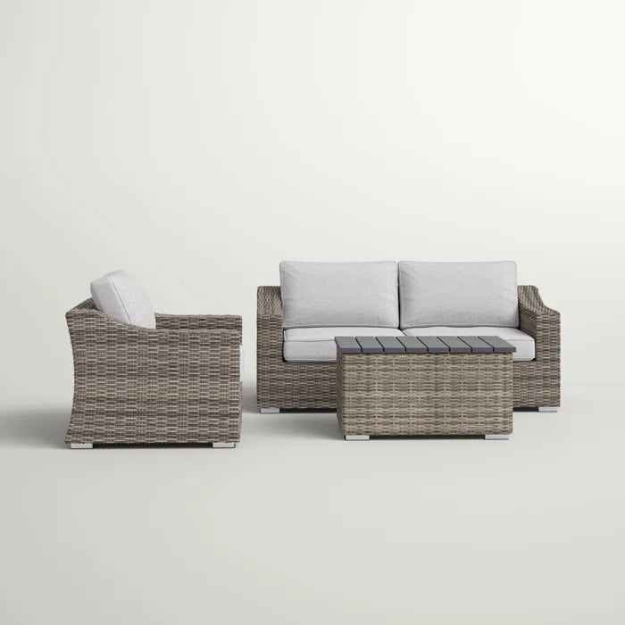 Gray wicker outdoor sofa set with light gray cushions and a dark gray slattop coffee table