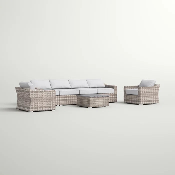 Light brown wicker sectional sofa with white cushions and matching coffee table