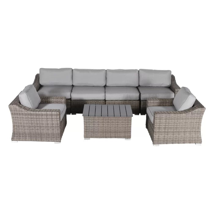Gray wicker sectional sofa with light gray cushions and a matching coffee table