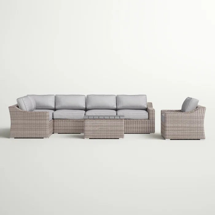 Woven rattan sectional outdoor sofa with grey cushions and coffee table