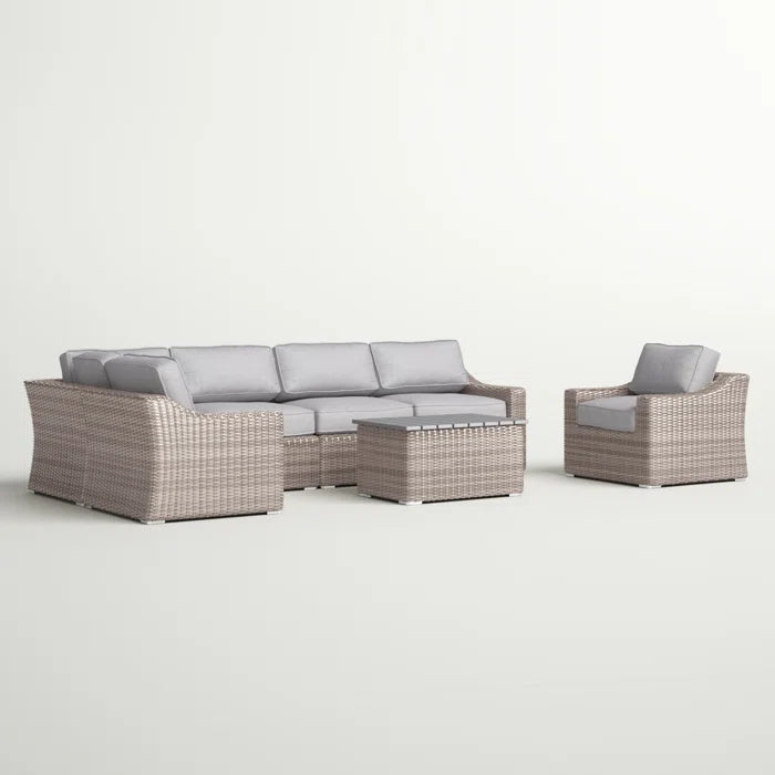 Grey wicker sectional sofa with coffee table and armchair for outdoor living