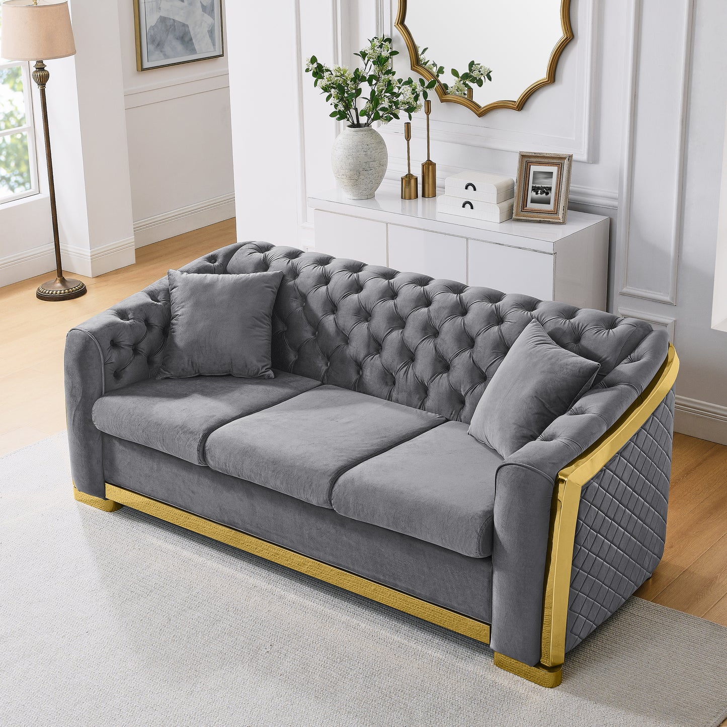 Luxurious grey velvet tufted sofa with gold accents and modern design