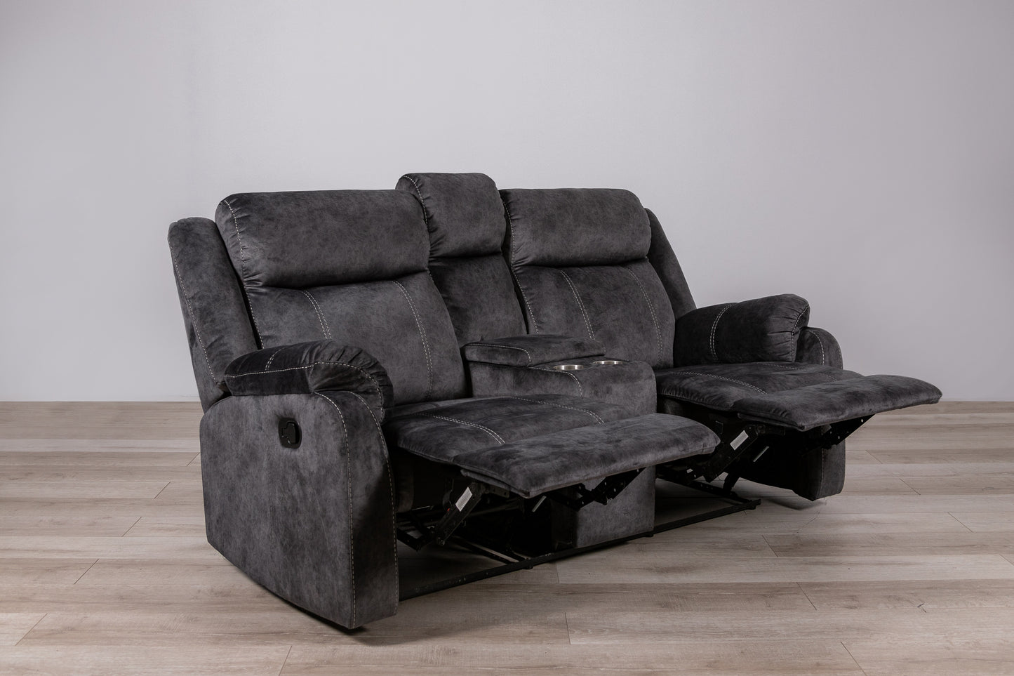 Dark gray fabric loveseat recliner with two cup holders and visible stitching details
