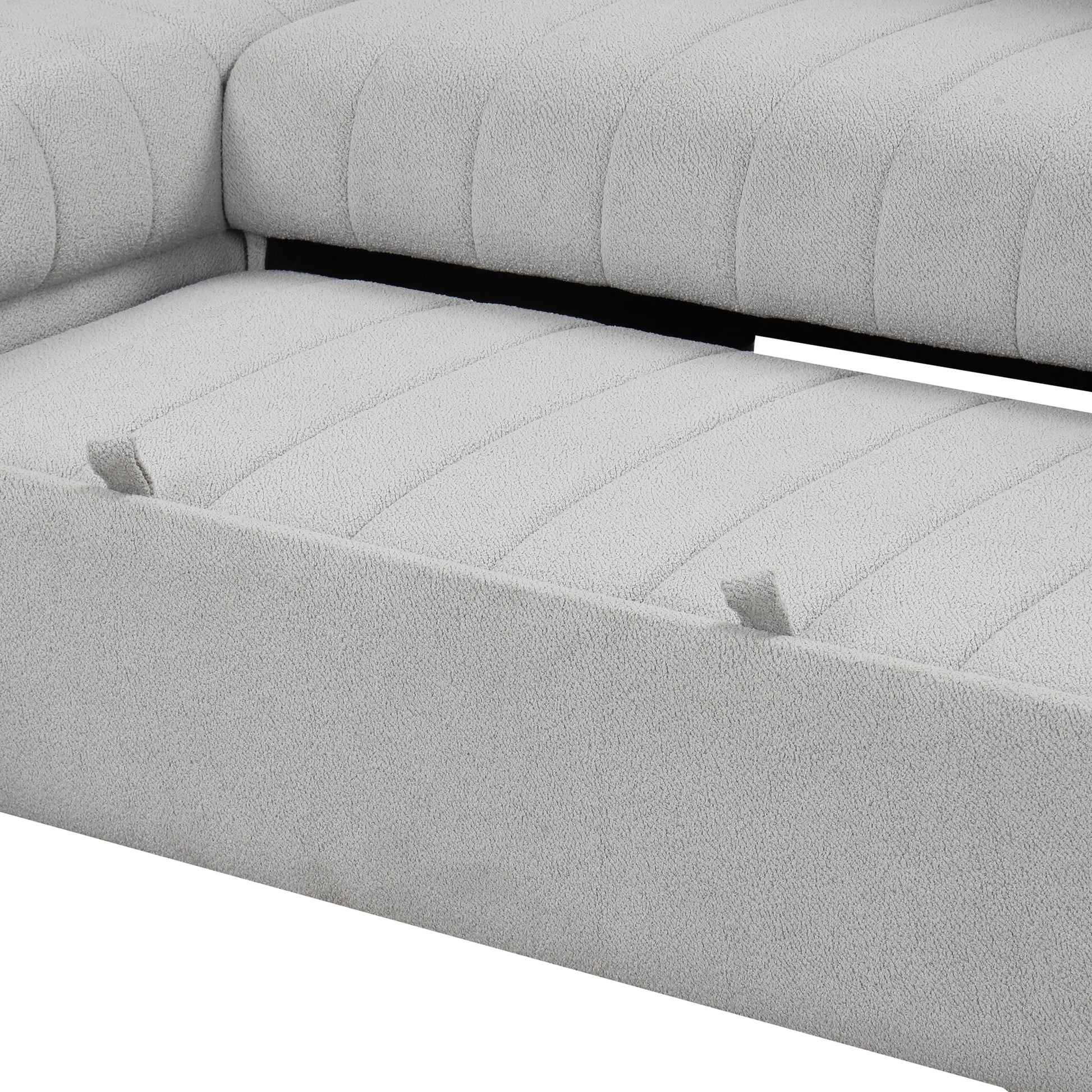 Closeup of a light grey textured fabric sofa with channel tufting