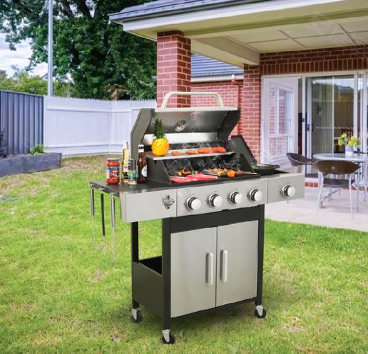 Stainless steel gas grill with four burners and double cabinet doors cooking food on a backyard patio