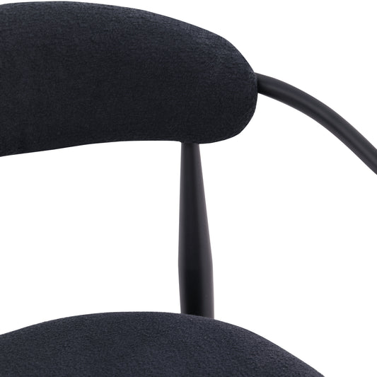 Black upholstered midcentury modern chair detail with curved back and tapered leg