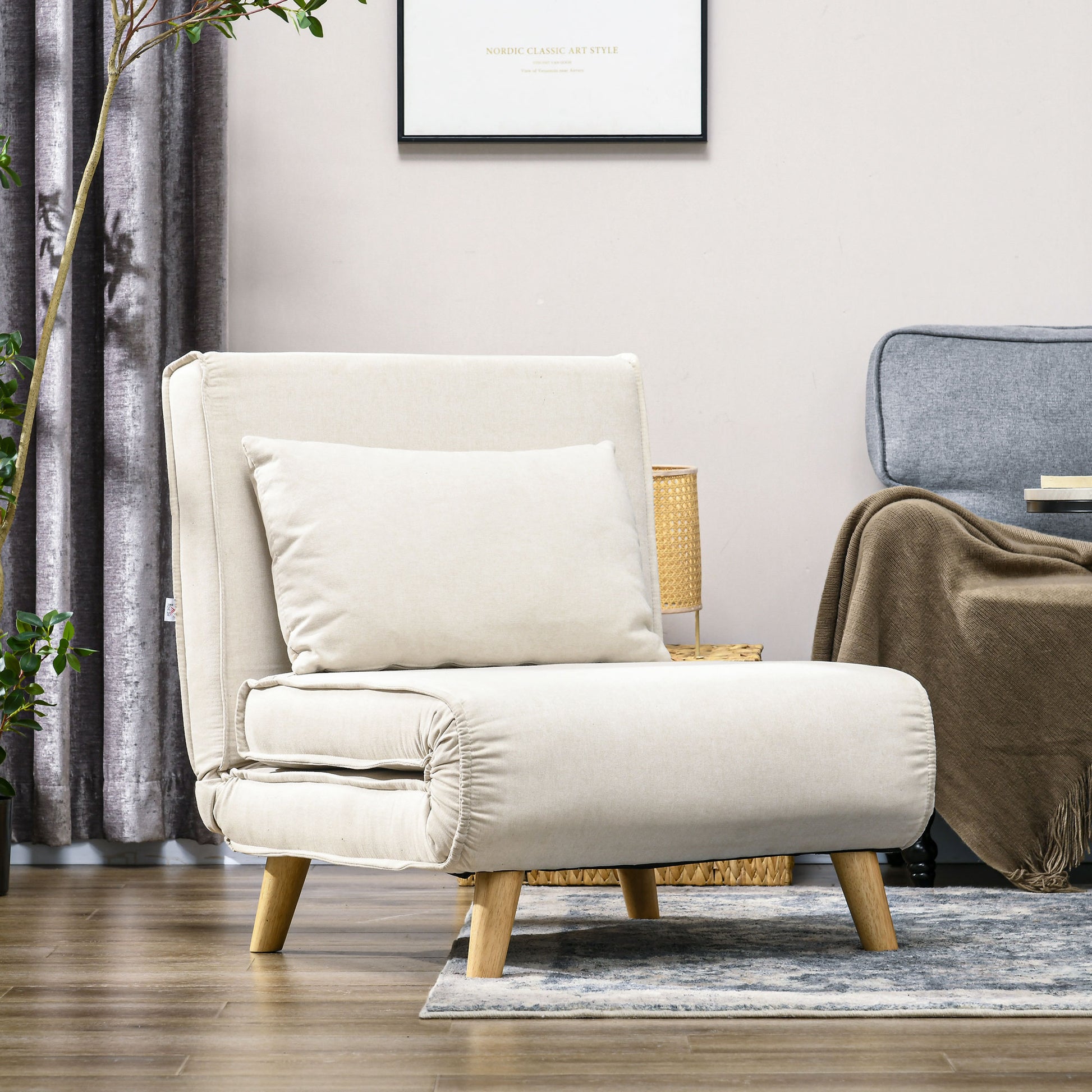 Cream upholstered convertible chair with wooden legs and a plush accent pillow