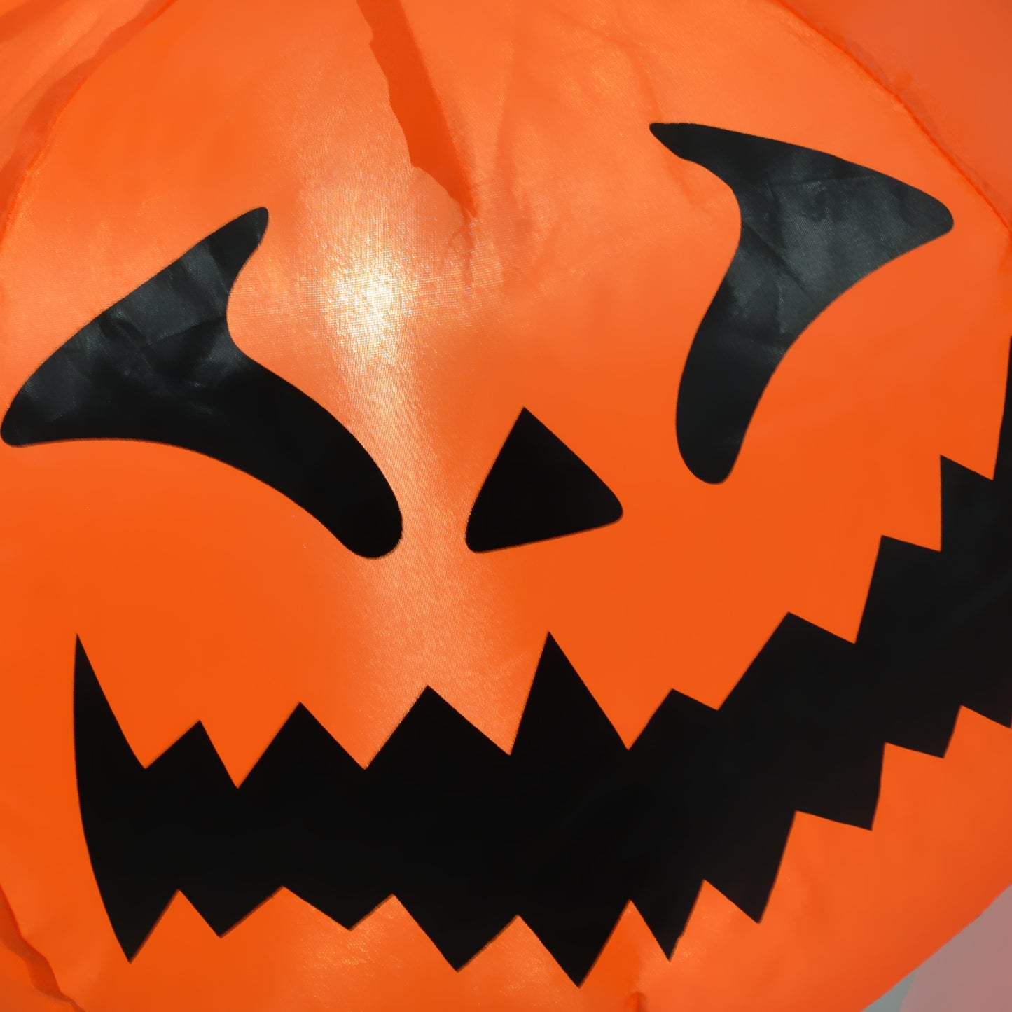 Orange inflatable Halloween decoration with a classic jackolantern face